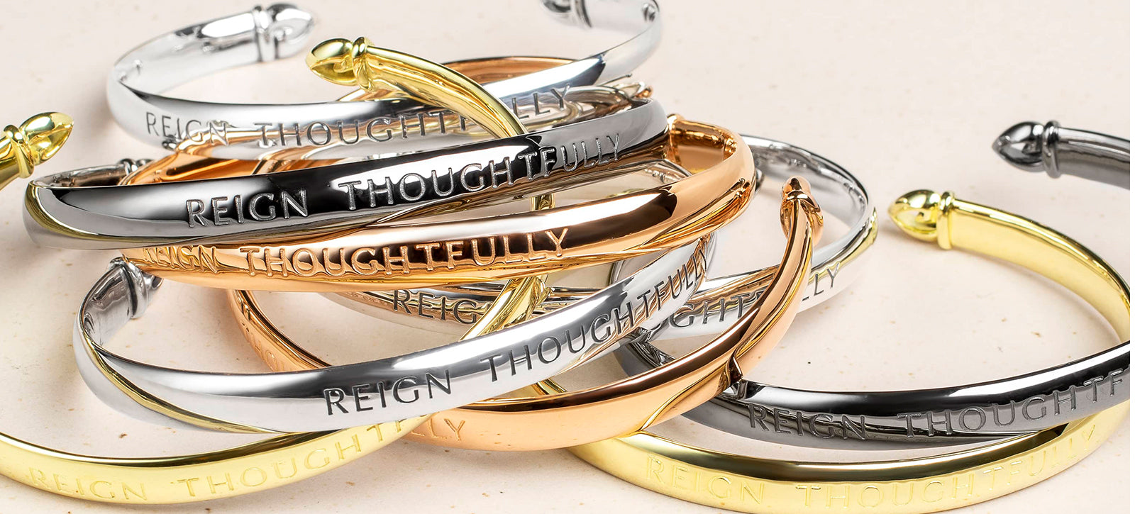 jumble of engraved Reign Thoughtfully Cuffs in four precious metal Shades of REALM